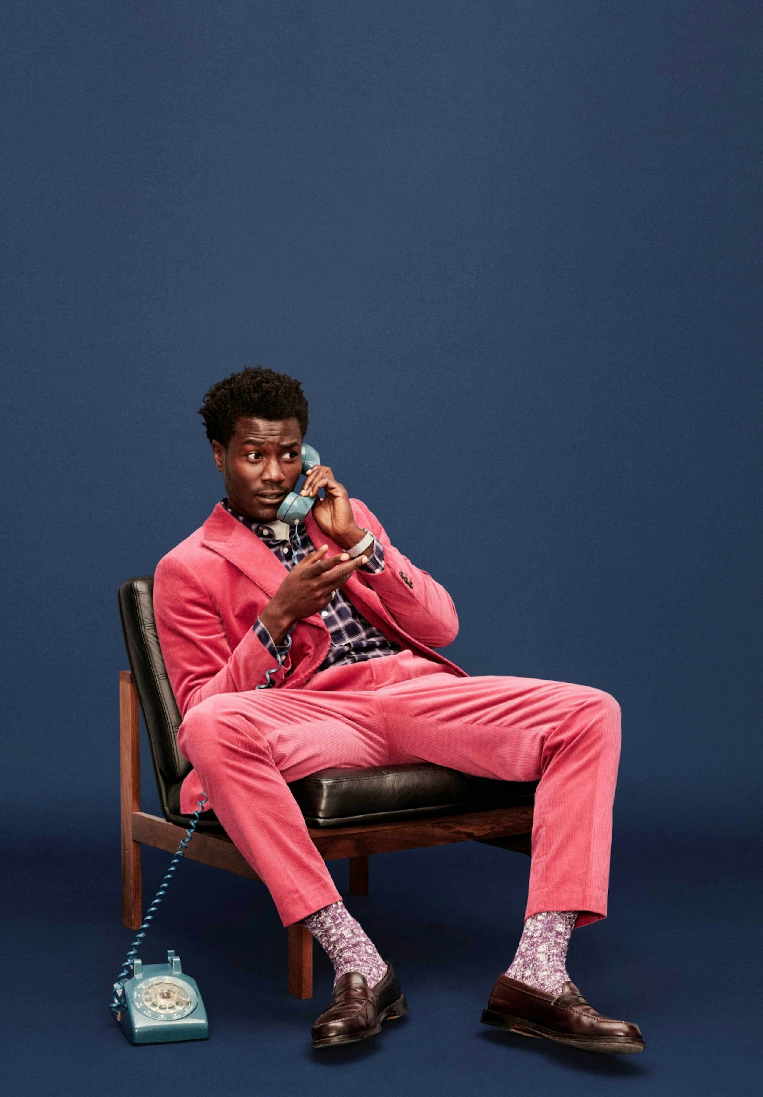 Man sitting wearing a Bonobos Suit and holding a phone