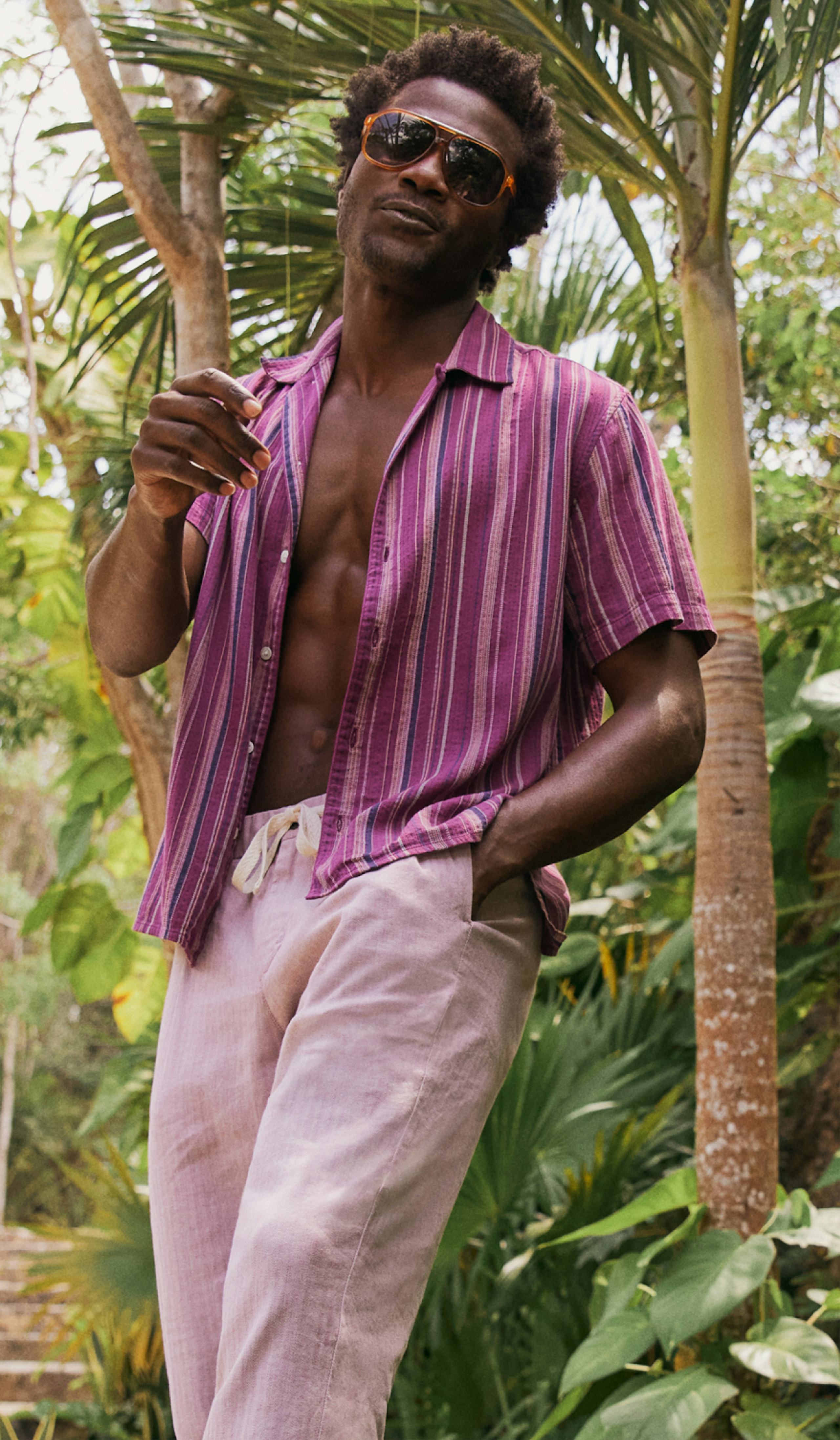 Model in tropics wearing Limited Edition Riviera Cabana Shirt in Burgundy Stripe