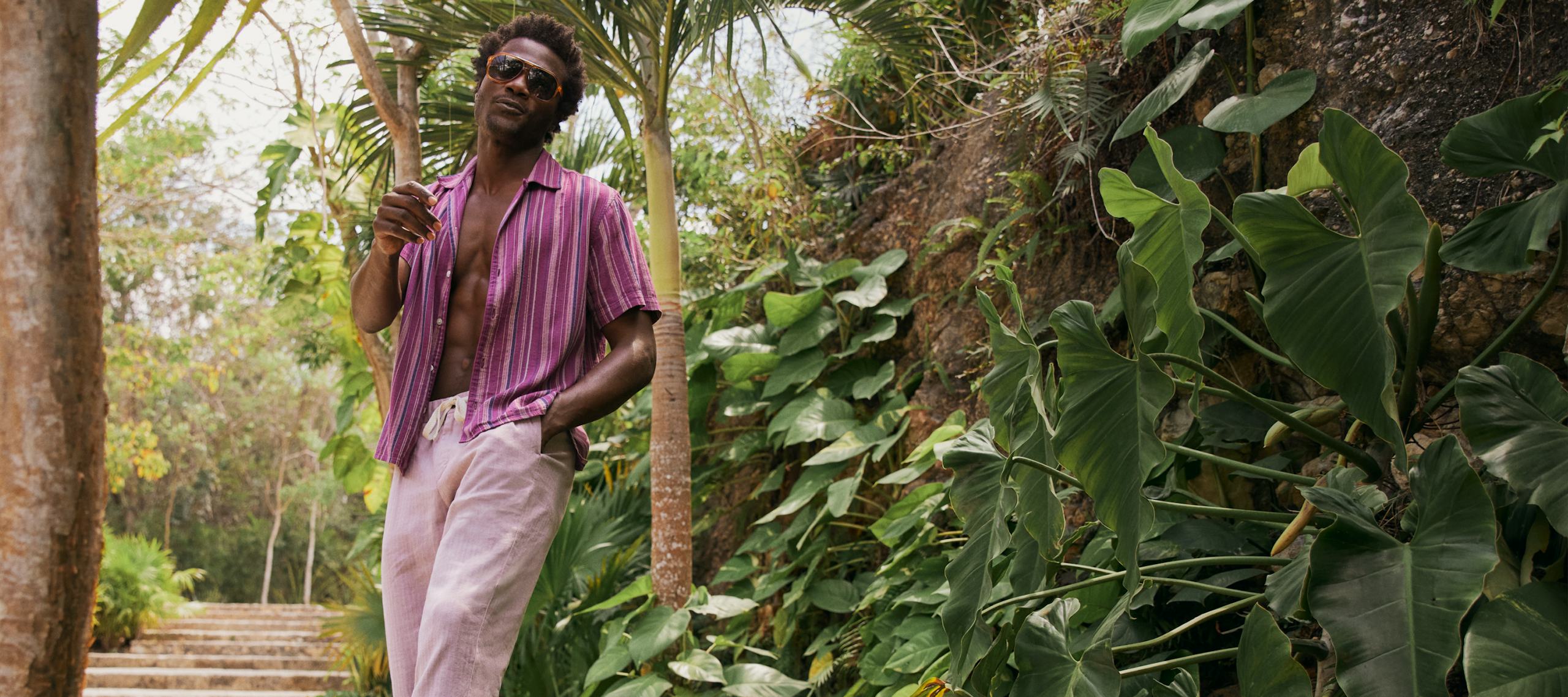 Model in tropics wearing Limited Edition Riviera Cabana Shirt in Burgundy Stripe